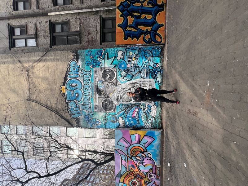 Portrait of Jay Loo in the Lower Eastside NYC, in front of colorful graffiti street art celebrating the 50th anniversary of Hip-Hop